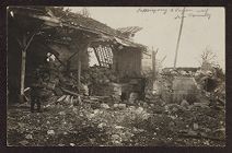Uniformed soldier in front of a partially destroyed building